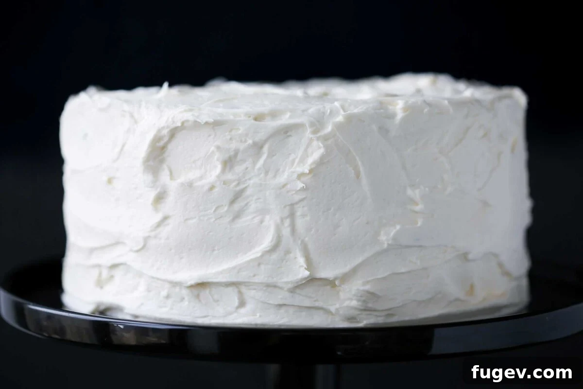 Elegant White Layer Cake 3 An entire beautifully frosted classic white cake, ready for slicing.