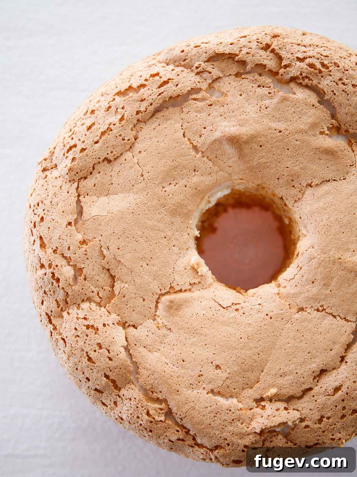 Heavenly Cloud Delight 4 A freshly baked, unsliced angel food cake, golden brown on top, resting in its tube pan.
