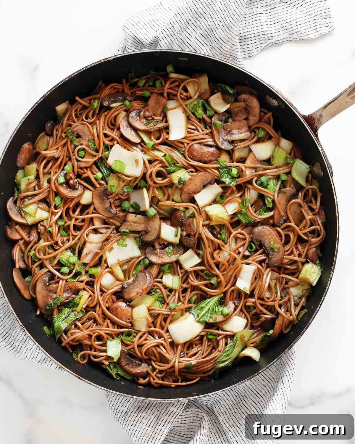 Earthy Mushroom & Crisp Bok Choy Soba Stir-Fry 2 A vibrant mushroom and bok choy soba noodle stir-fry beautifully plated in a skillet, showcasing fresh ingredients.
