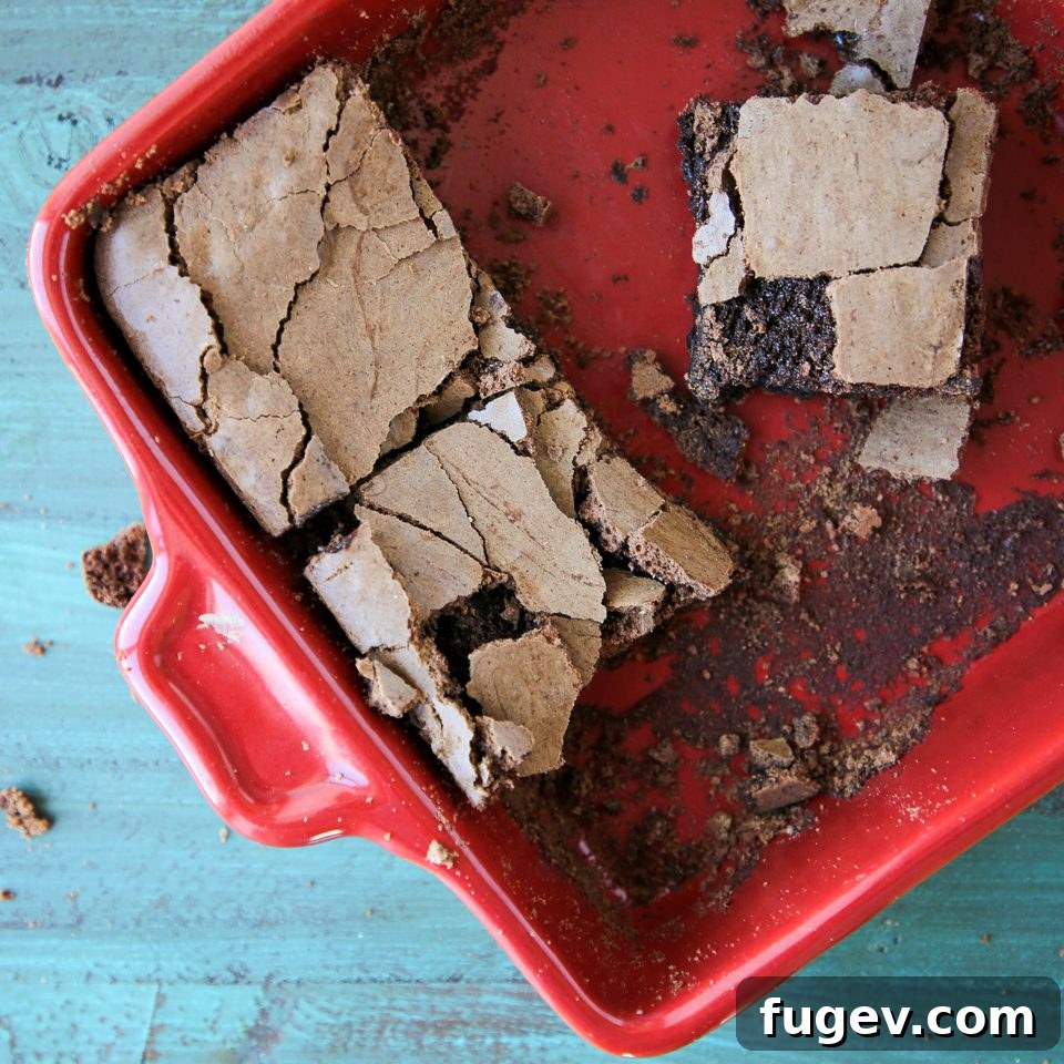 Golden Brown Butter Indulgence 4 Brown butter brownies cooling in a vibrant red baking dish, showing off their perfect crinkled tops.