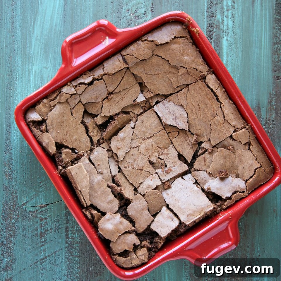 Golden Brown Butter Indulgence 5 A perfectly baked pan of brown butter brownies cooling on a blue countertop, showcasing their uniform crackled surface.