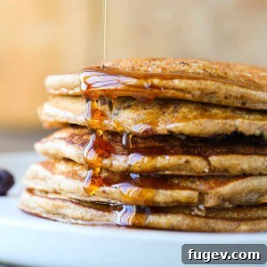 Whole wheat pancakes stacked with maple syrup