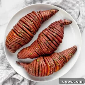 3 hasselback potatoes on a plate.