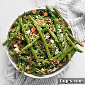 Roasted green beans topped with breadcrumbs and almonds in a bowl, showcasing their vibrant color and crispy texture.