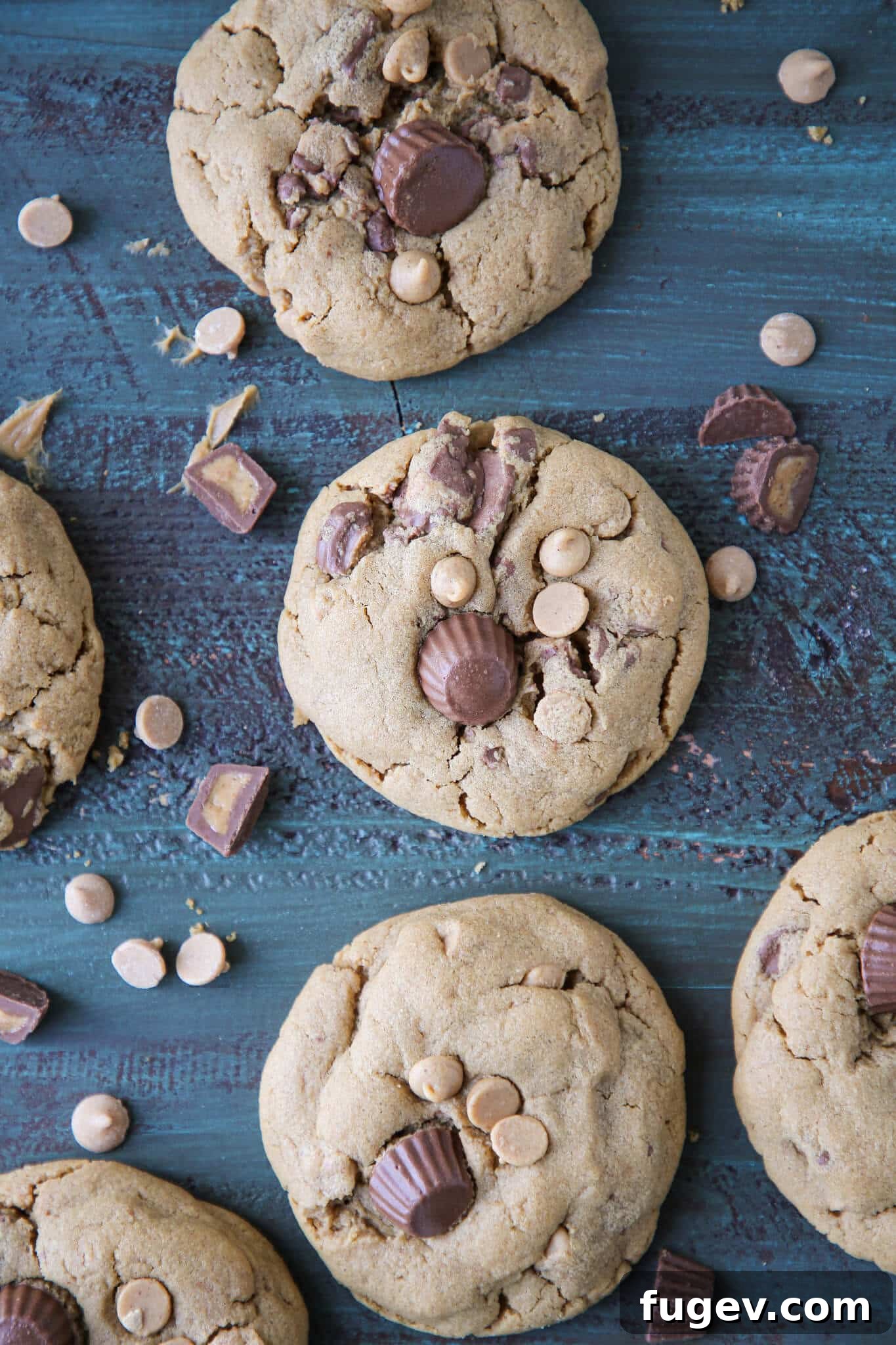 Irresistible Reese's Peanut Butter Cookies 2 Stacked Reese's Peanut Butter Cookies on a wooden surface, showcasing their thick, chewy texture and generous mix-ins.