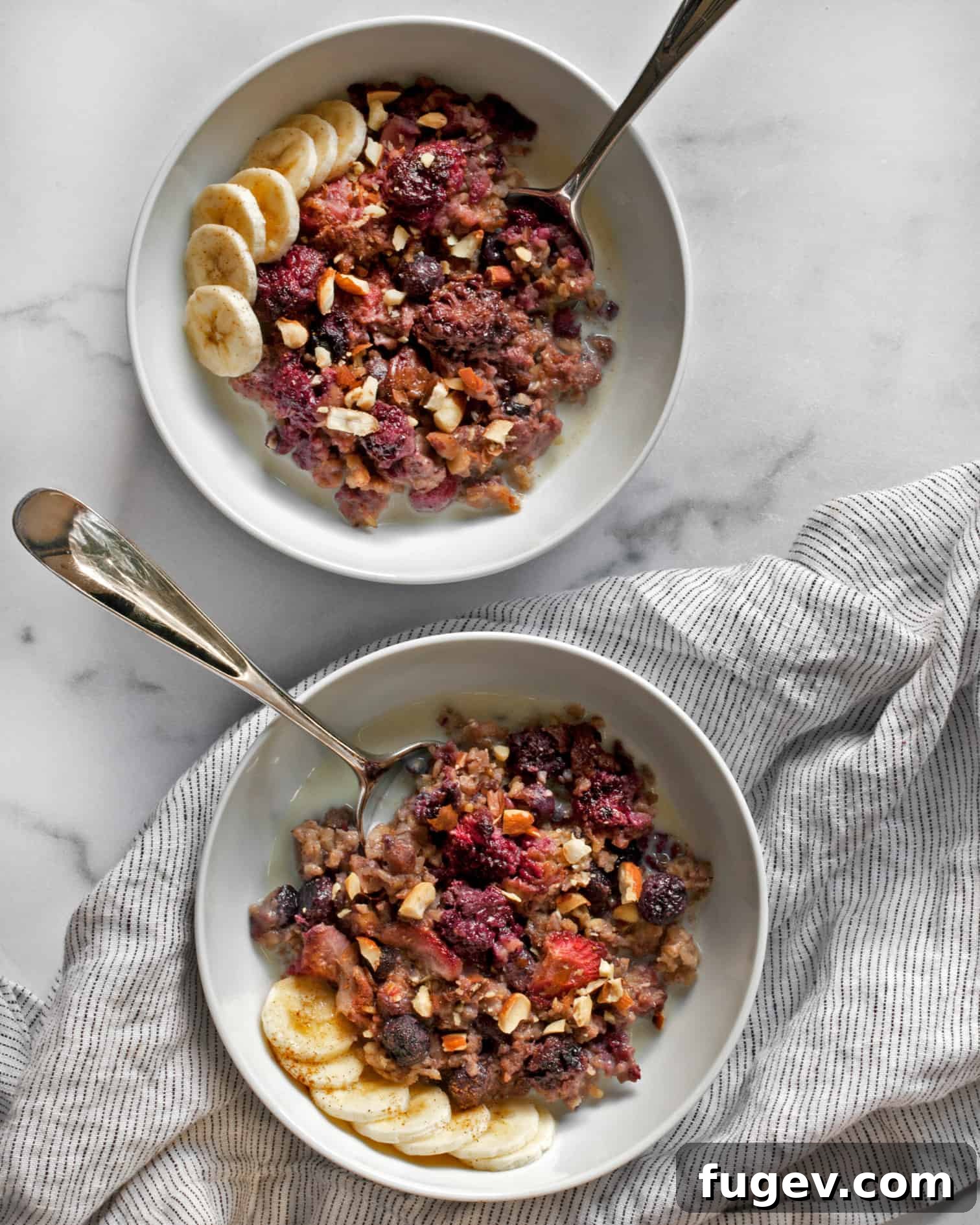 Baked Berry Steel-Cut Oats 11 Berry baked steel-cut oatmeal in two bowls topped with banana slices and cinnamon