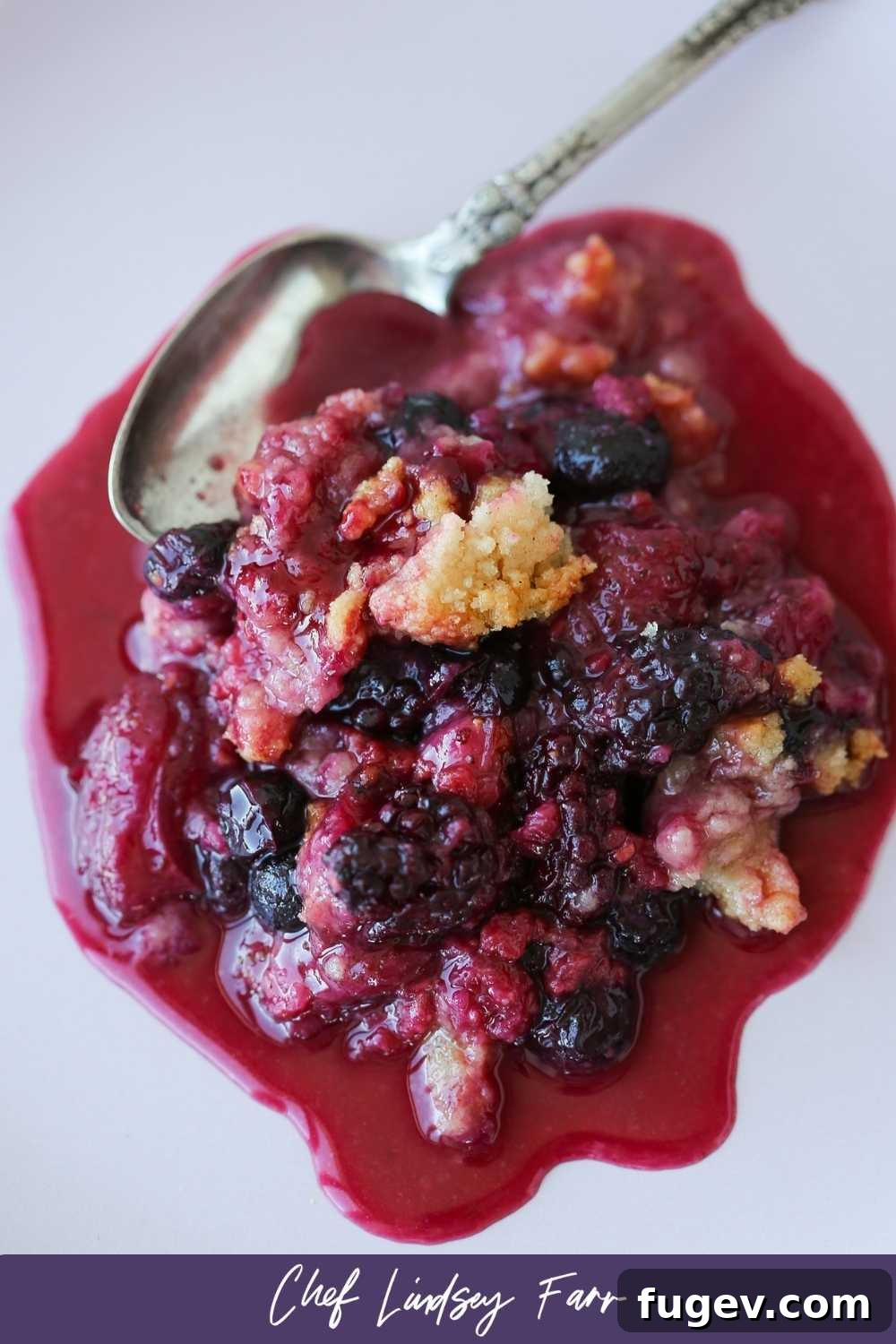 Irresistible Berry Crumble 7 Mixed Berry Crumble Spoonful - a close-up image of a spoon scooping the crumble.