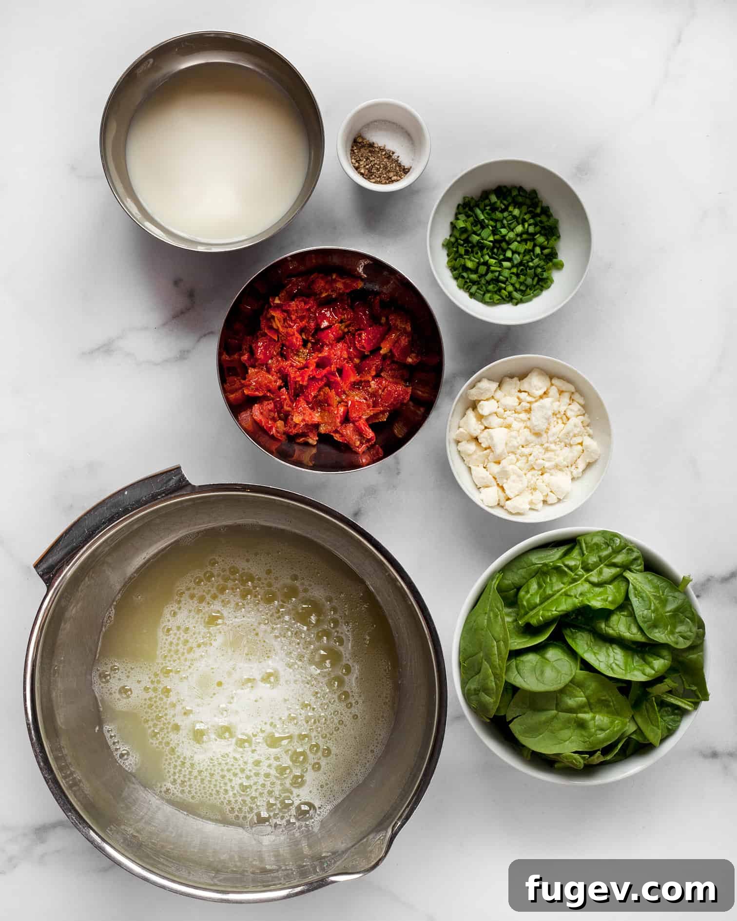 Fluffy Spinach Feta Protein Poppers 3 A flat lay image showing all the ingredients required for the egg white bites recipe, including carton egg whites, milk, roasted tomatoes, fresh spinach, and crumbled feta cheese.