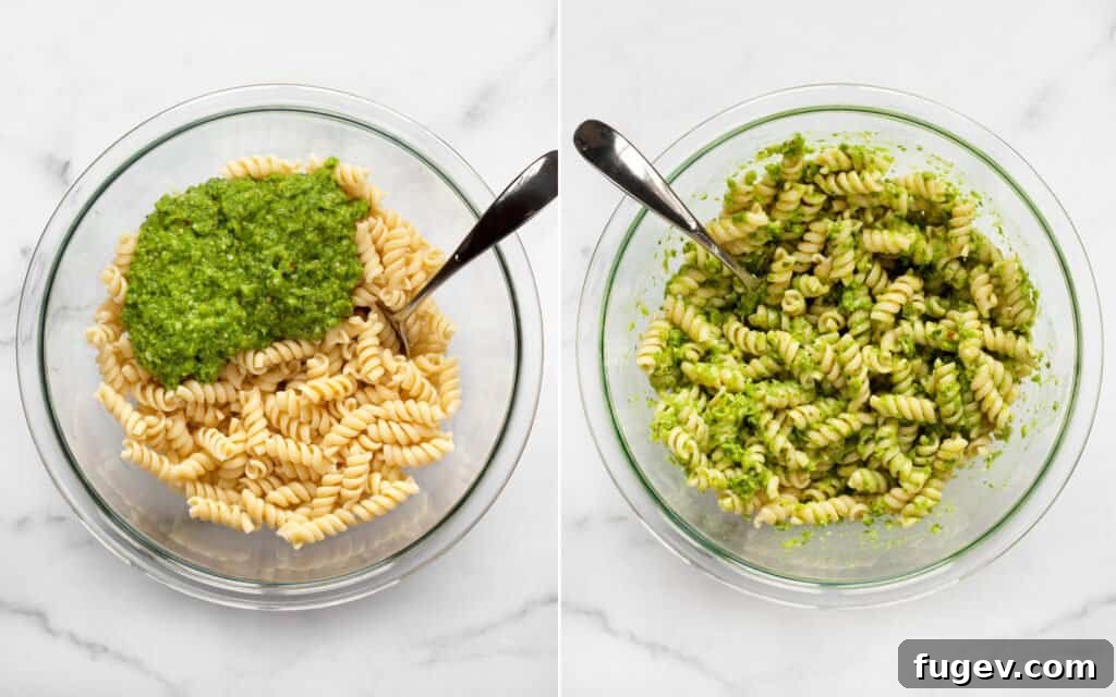 Emerald Green Pea Pesto Pasta 5 A close-up shot of fusilli pasta being stirred with vibrant green pea pesto in a large bowl.