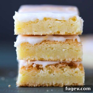 Three lemon blondies featured with a vibrant lemon glaze, ready to be enjoyed.