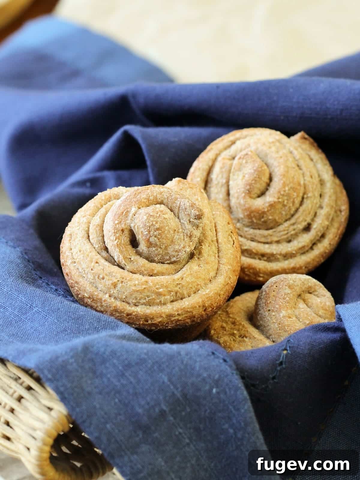 Rustic Wheat Rolls 6 A single whole wheat roll, meticulously shaped in a tight spiral, beautifully showcasing the intricate twisted swirl formed during baking.