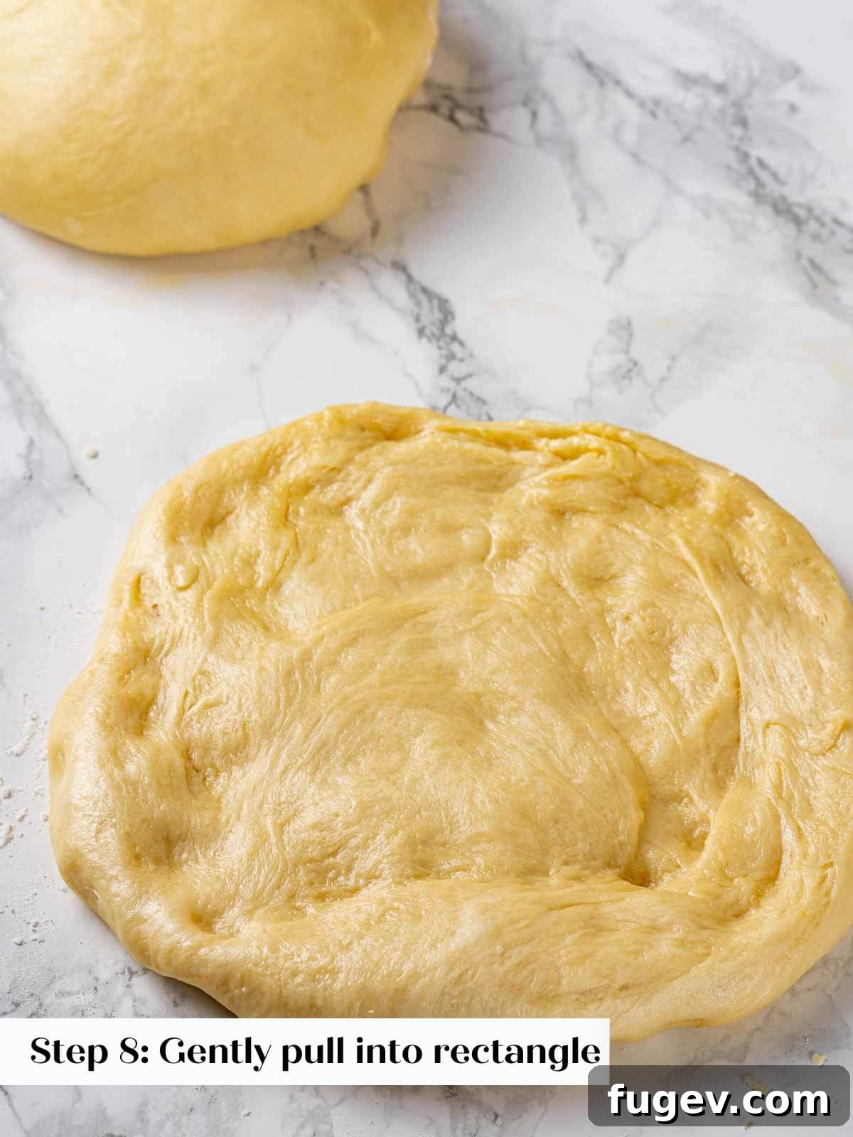 Golden Buttery Brioche Loaf 11 Pressing brioche dough into a rectangular shape on a floured surface.