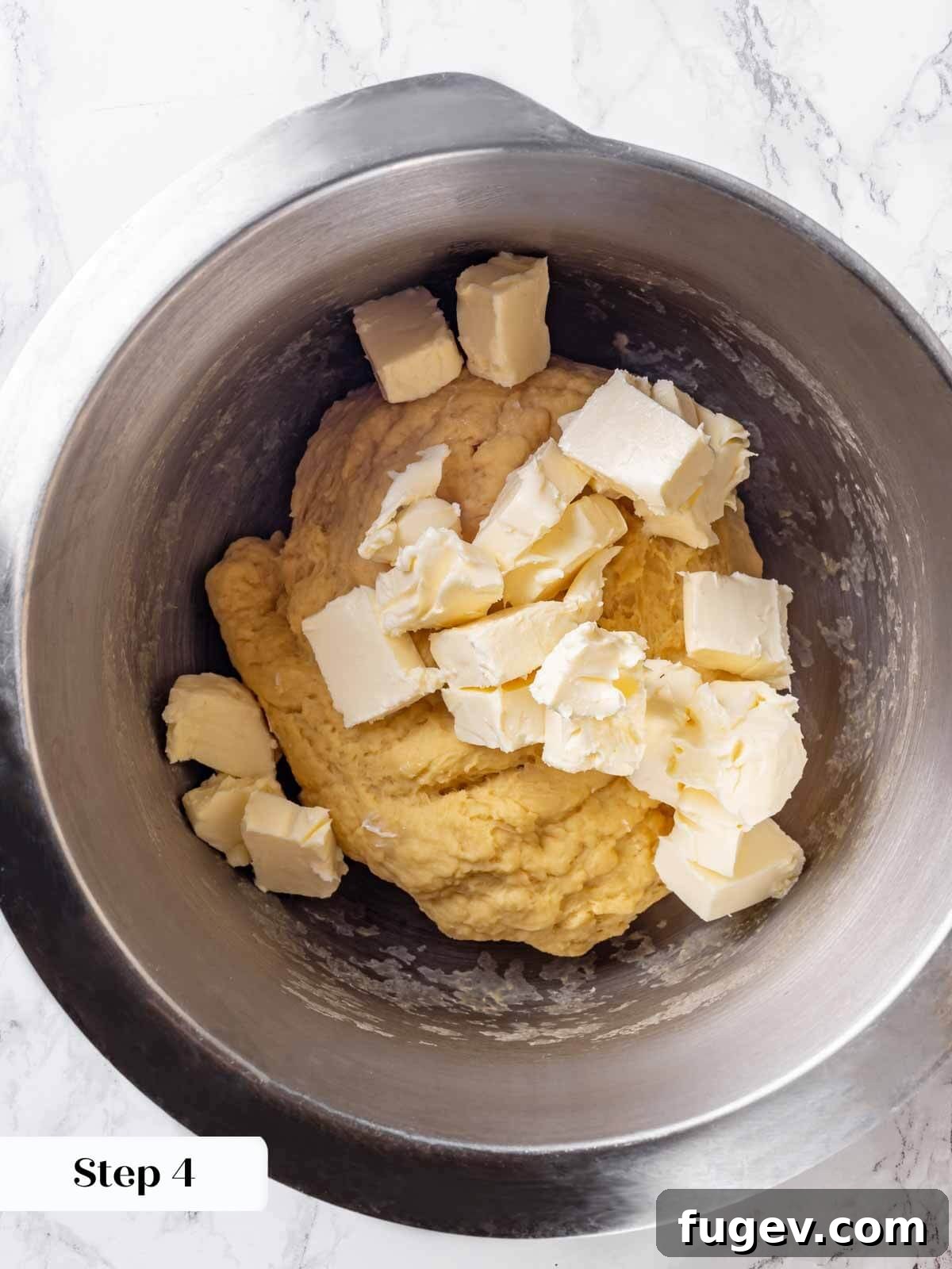 Golden Buttery Brioche Loaf 8 Adding softened butter to the brioche dough in a stand mixer.