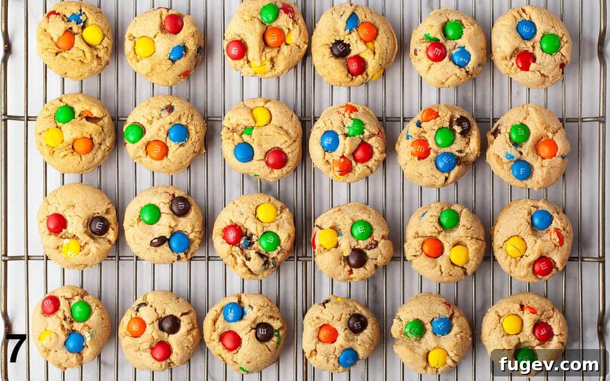 Chewy Peanut Butter Chocolate Candy Cookies 7 Freshly baked Peanut Butter M&M cookies cooling on a wire rack, showing their golden brown edges and vibrant chocolate candies.