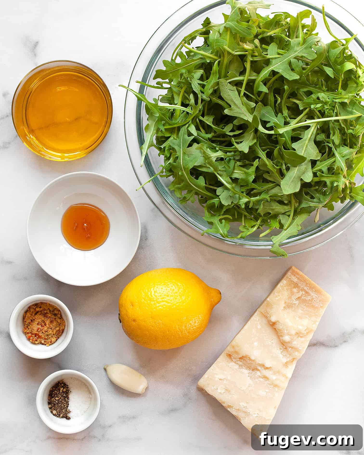 Lemon-Kissed Arugula Salad 3 Key ingredients for arugula salad and lemon vinaigrette: fresh arugula, lemon, Parmesan cheese, olive oil, honey, garlic, and Dijon mustard.