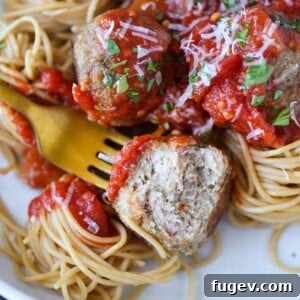 Baked turkey meatballs with one bitten open to show the tender interior.