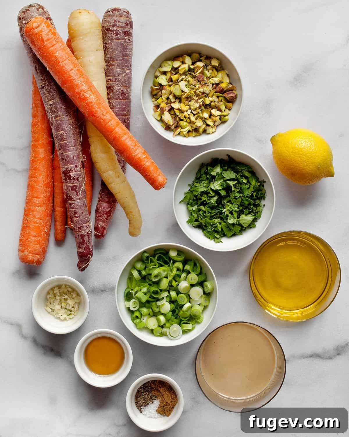Vibrant Carrot Salad with Creamy Lemon Tahini 4 A flat lay photograph showcasing the fresh ingredients required for the carrot salad: vibrant carrots, a bunch of scallions, a bowl of pistachios, a sliced lemon, and a bottle of olive oil.