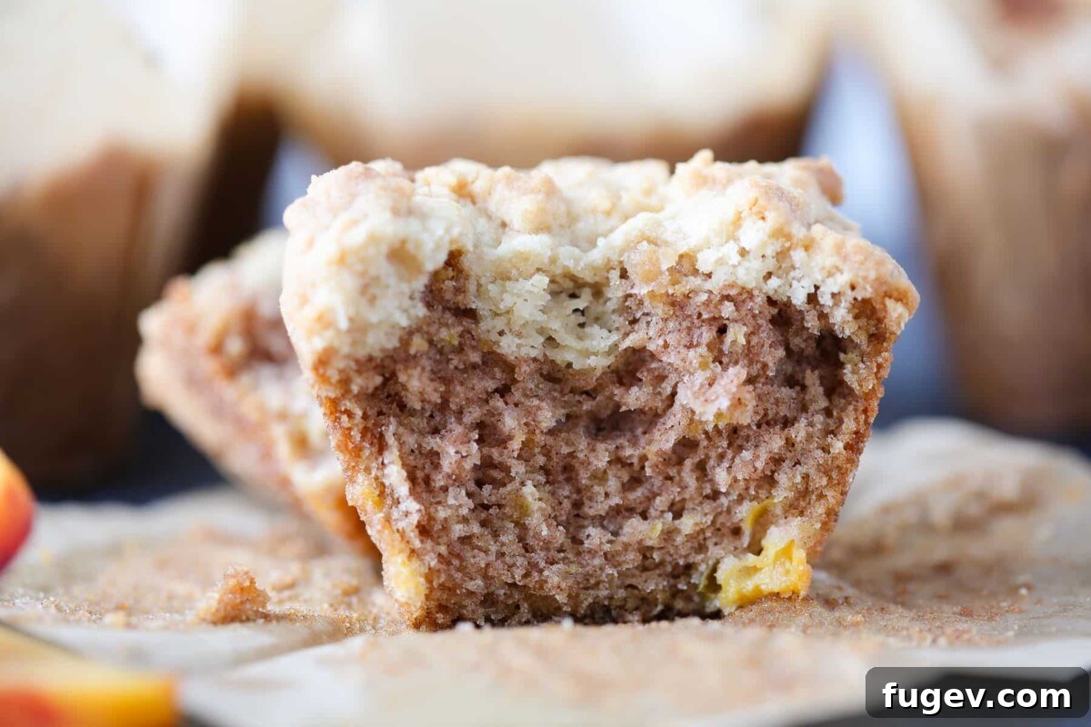 Luscious Peach Muffins 3 Halved peach muffin showing its incredibly moist interior crumb and generous chunks of baked peach throughout.