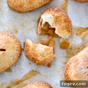 Flaky Apple Turnovers 14 Close-up overhead shot of baked apple hand pies on a baking sheet.