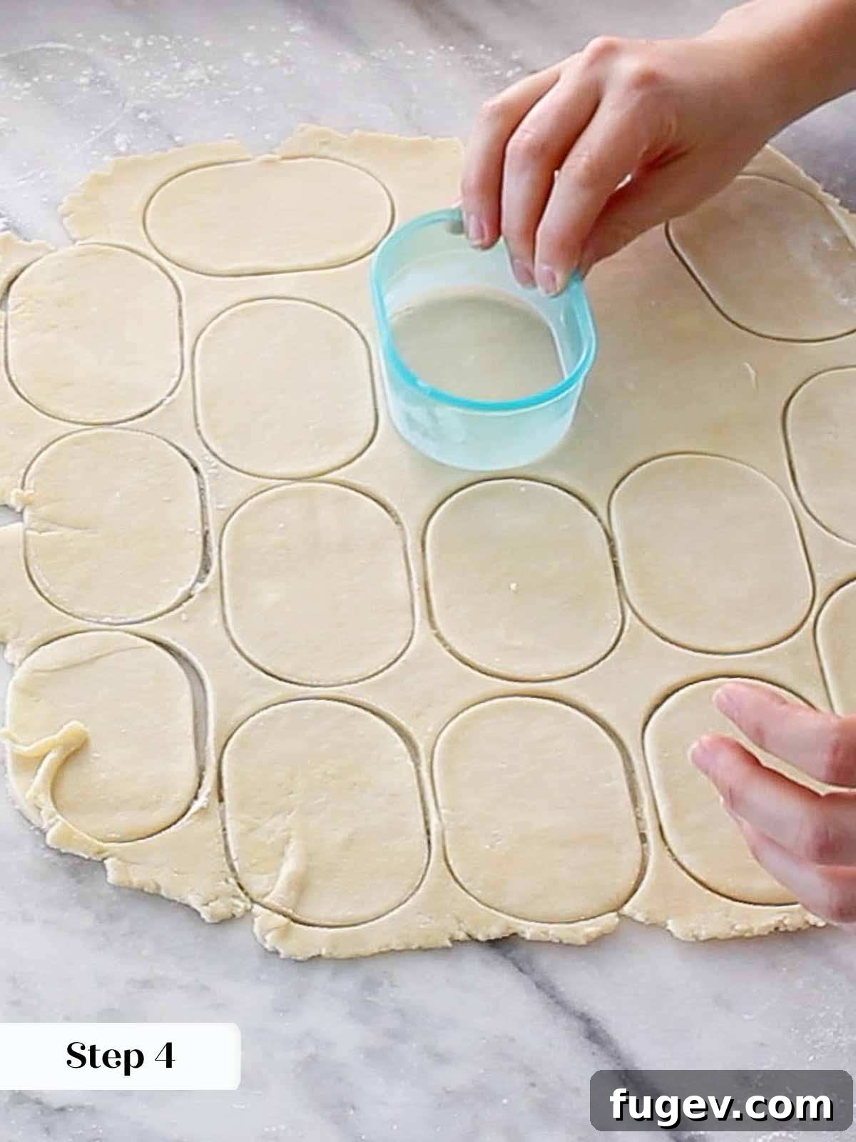 Flaky Apple Turnovers 7 Rolling out pie dough and cutting out uniform shapes with a cookie cutter for hand pies.