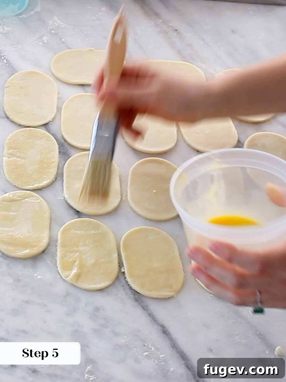 Flaky Apple Turnovers 8 Brushing beaten egg wash onto the edges of pie dough cutouts before adding filling.
