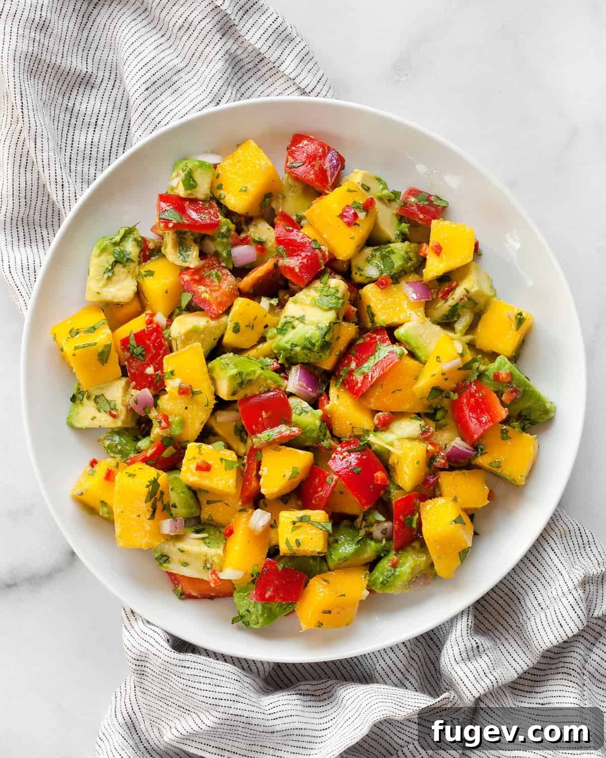 Refreshing Mango Avocado Medley 6 A portion of fresh mango avocado salad served on a plate, ready to be enjoyed.
