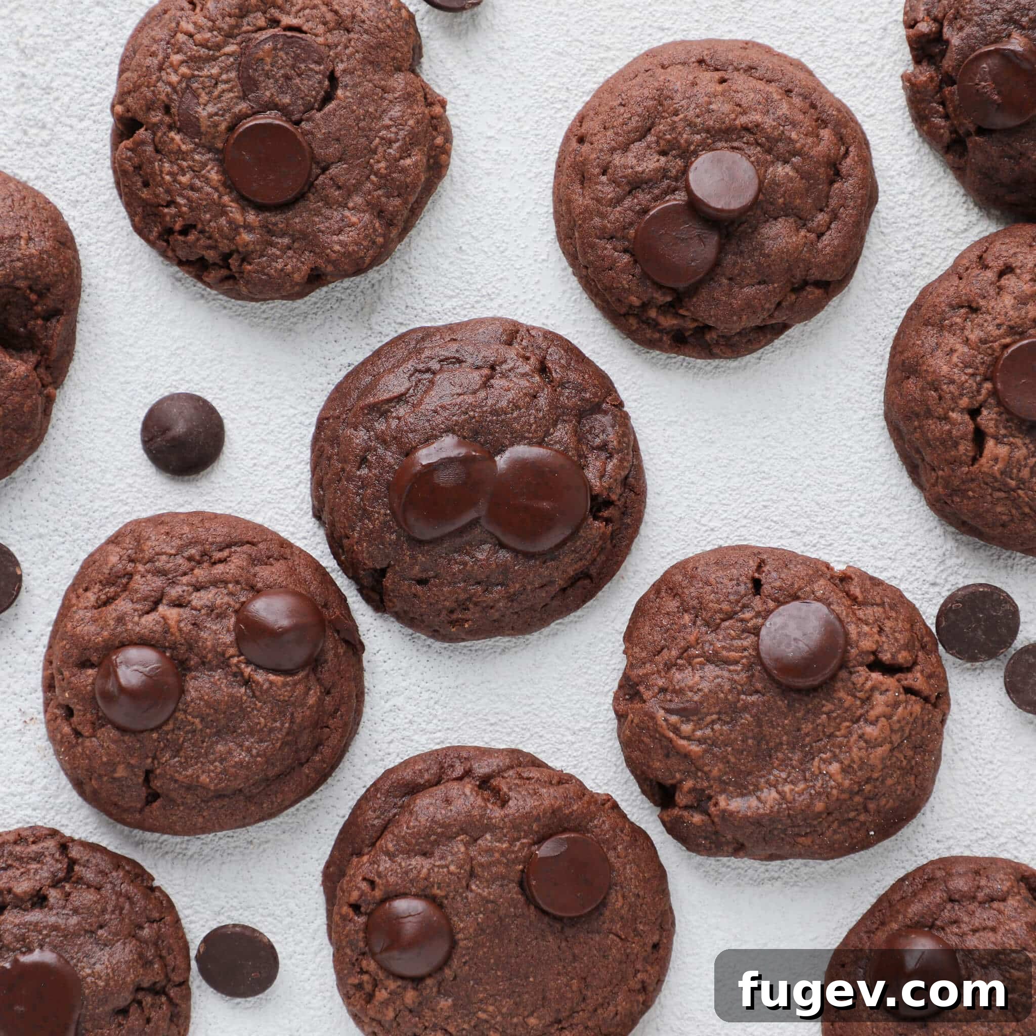 Chocolate Overload Pudding Cookies 4 Top view of Quadruple Chocolate Pudding Cookies arranged on a white board, highlighting their dark color and inviting appearance.