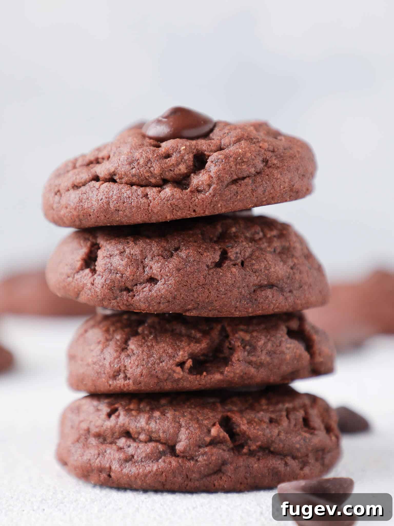 Chocolate Overload Pudding Cookies 5 A stack of perfectly baked Quadruple Chocolate Pudding Cookies on a white background, showcasing their rich color and inviting texture.