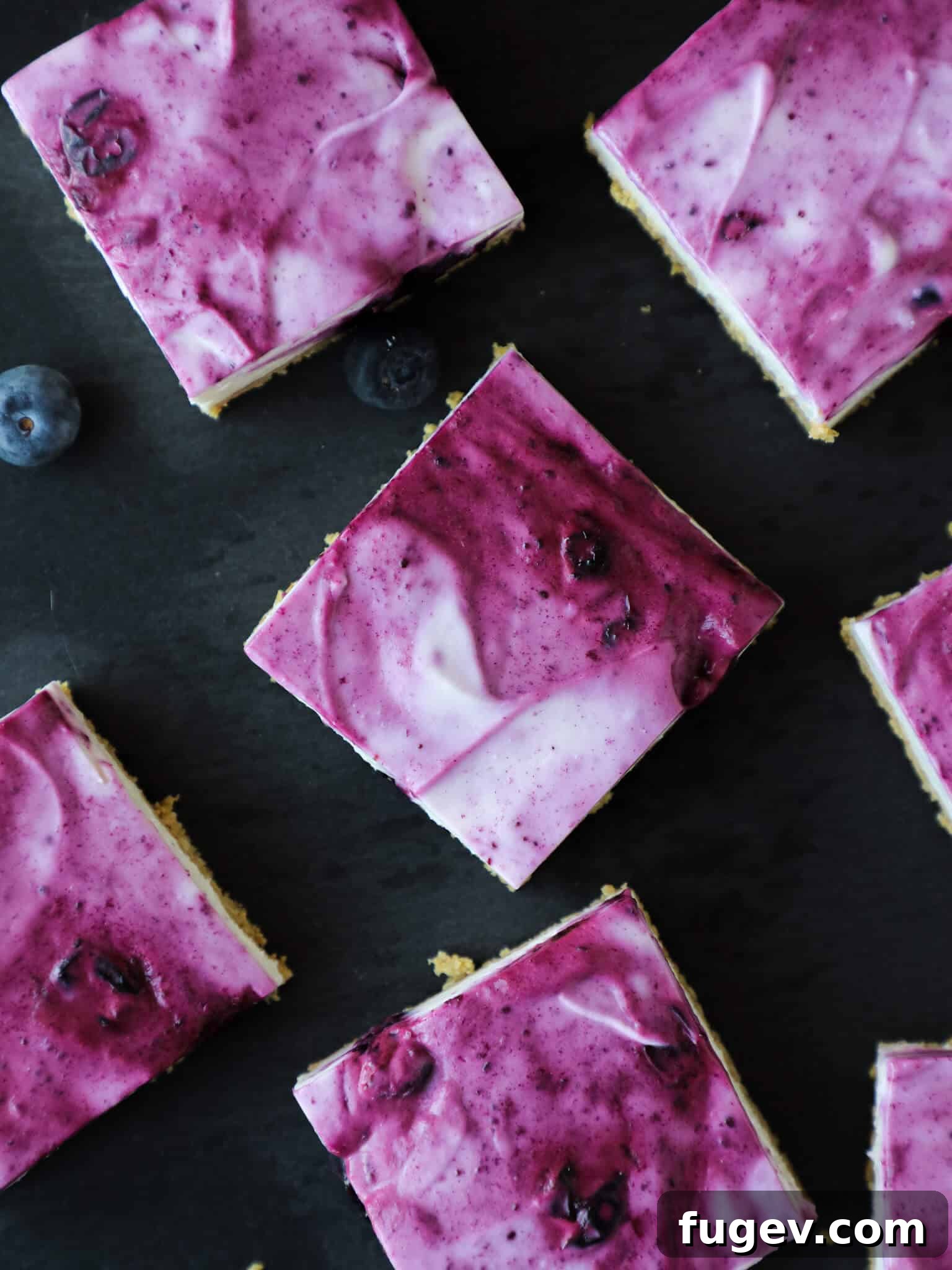 Refreshing No Bake Blueberry Cheesecake Squares 2 No Bake Blueberry Cheesecake Bars Sliced, showing distinct layers of crust, creamy filling, and blueberry swirl.