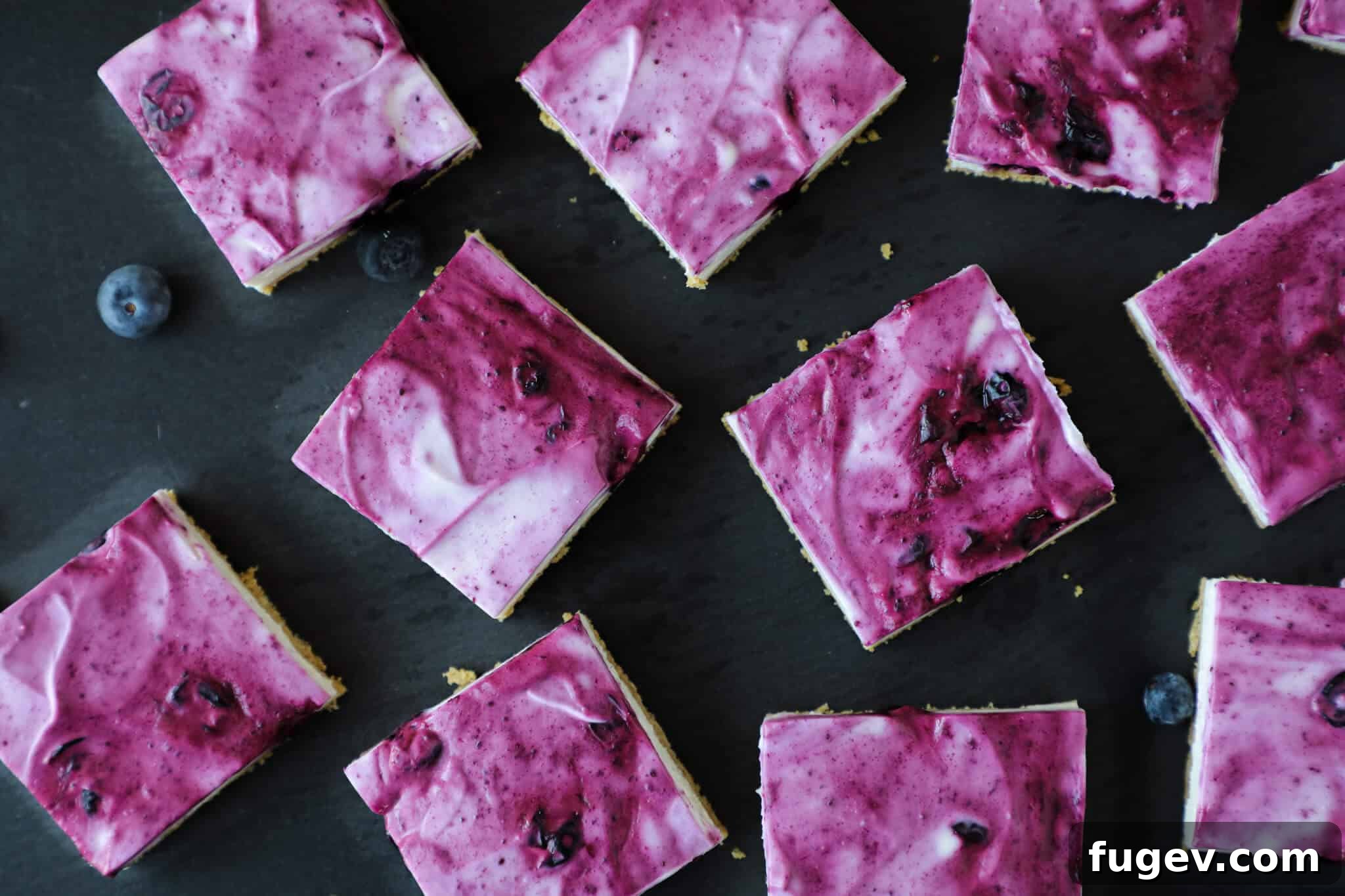 Refreshing No Bake Blueberry Cheesecake Squares 4 No Bake Blueberry Cheesecake Bars arranged neatly overhead, showcasing the beautiful swirl of blueberry jam.