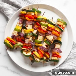 Grilled halloumi veggie skewers ready to be served on a plate.