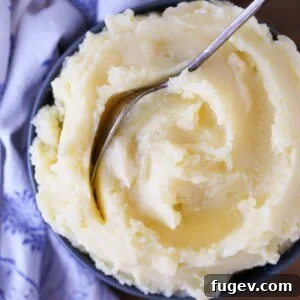 Creamy Mashed Potatoes in a blue bowl with a vintage spoon