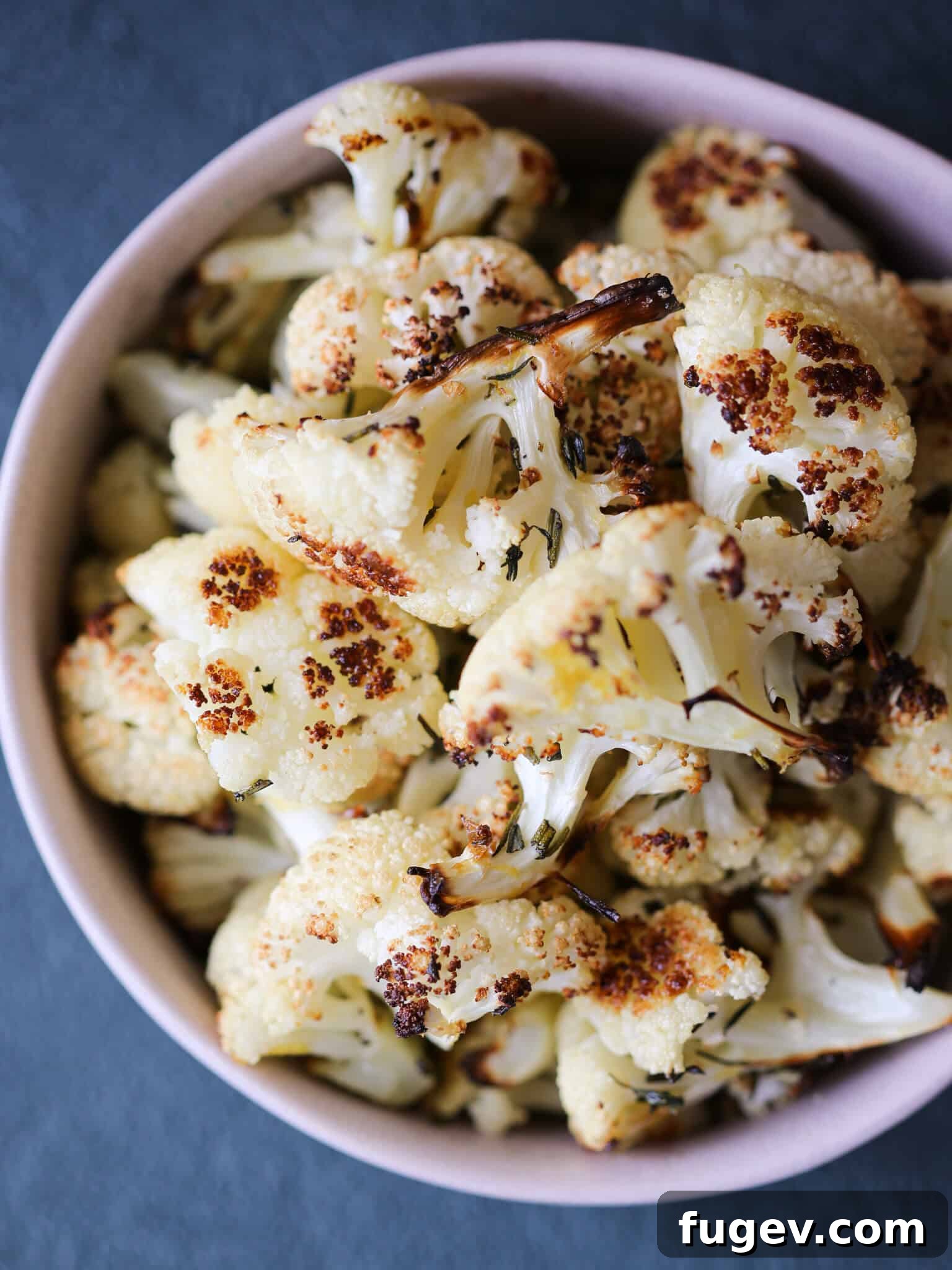 Zesty Rosemary Lemon Roasted Cauliflower 6 Easy Rosemary Lemon Roasted Cauliflower pink bowl on a green surface