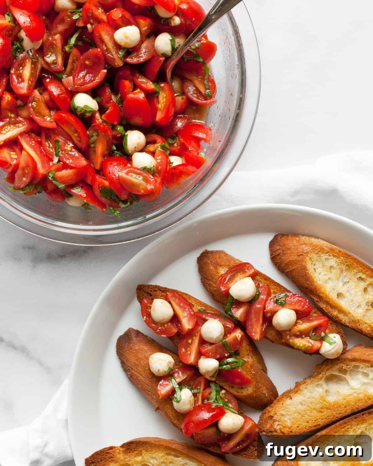 Caprese Bruschetta with Juicy Tomatoes and Creamy Mozzarella 6 A rustic presentation of a bowl overflowing with fresh Caprese bruschetta topping next to a plate of perfectly toasted, golden-brown bread slices, ready for assembly.