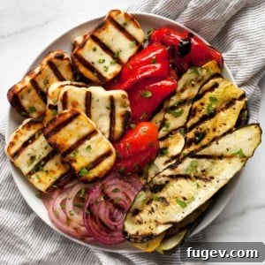 Grilled zucchini, squash, peppers and onions with grilled halloumi on a plate.