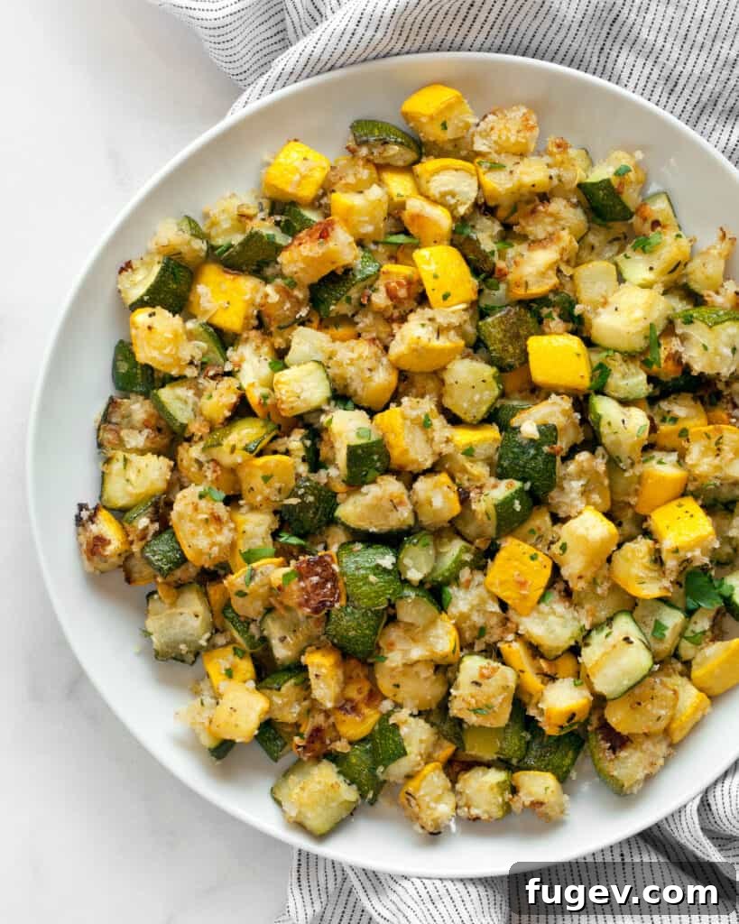 Golden Roasted Zucchini and Squash 2 Perfectly roasted zucchini and yellow squash, golden brown with crispy panko and Parmesan, served on a plate.