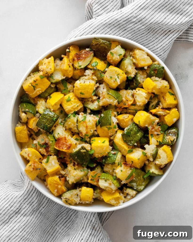 Golden Roasted Zucchini and Squash 8 A generous serving of roasted zucchini and yellow squash with panko and Parmesan, presented in a rustic ceramic bowl.