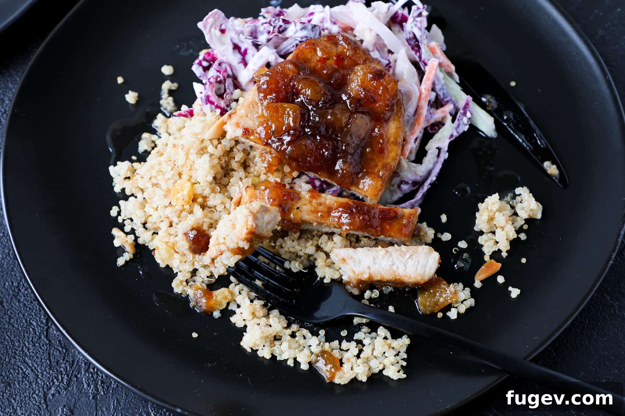 Sweet Heat Peach Pork Chops 4 A tender Spicy Peach Pork Chop, perfectly seared and glazed, ready to be enjoyed with a black fork poised to cut into it.