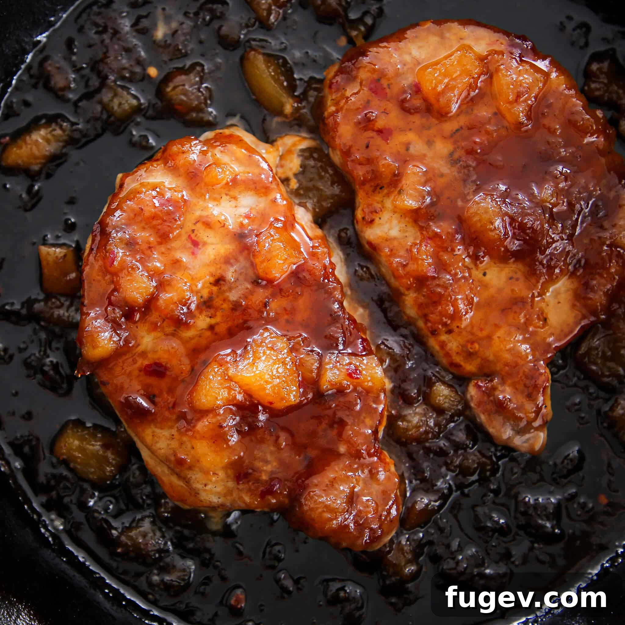 Sweet Heat Peach Pork Chops 5 Spicy Peach Pork Chops searing in a cast iron skillet on the stovetop before going into the oven.
