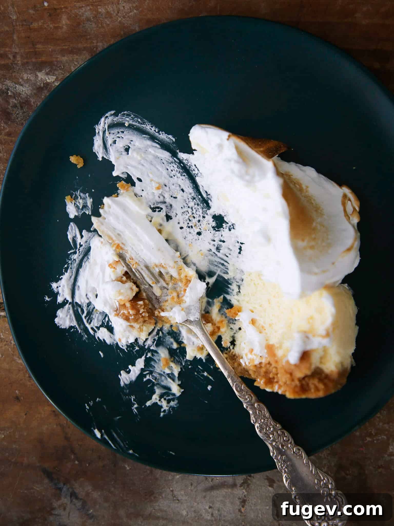 Zesty Lemon Cloud Cheesecake 3 A delectable slice of Lemon Meringue Cheesecake, perfectly plated with a generous dollop of meringue.