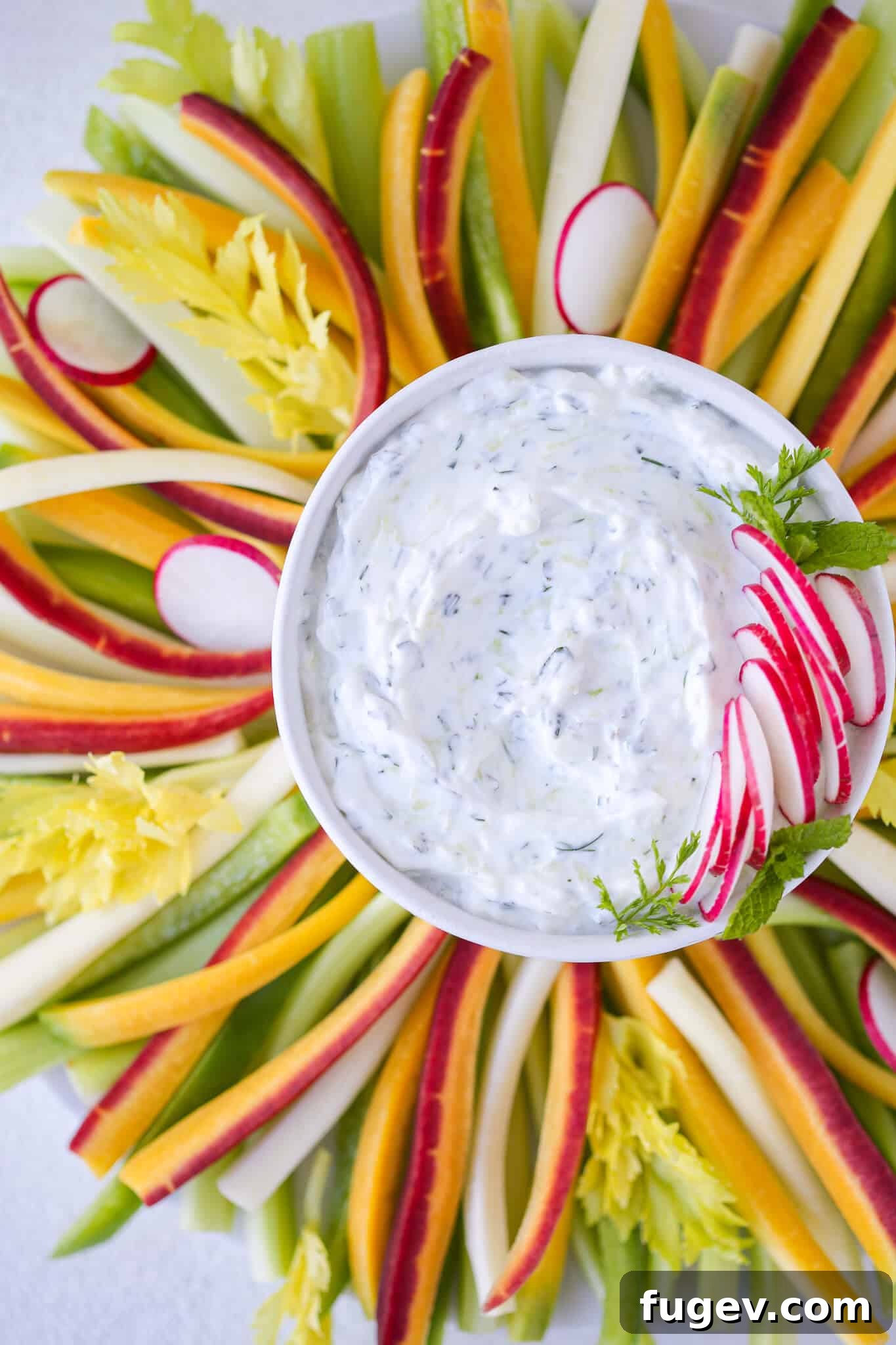 Refreshing Greek Tzatziki 2 Freshly made Tzatziki Dip garnished with fresh dill and a delicate swirl of olive oil, presented in an elegant white bowl.