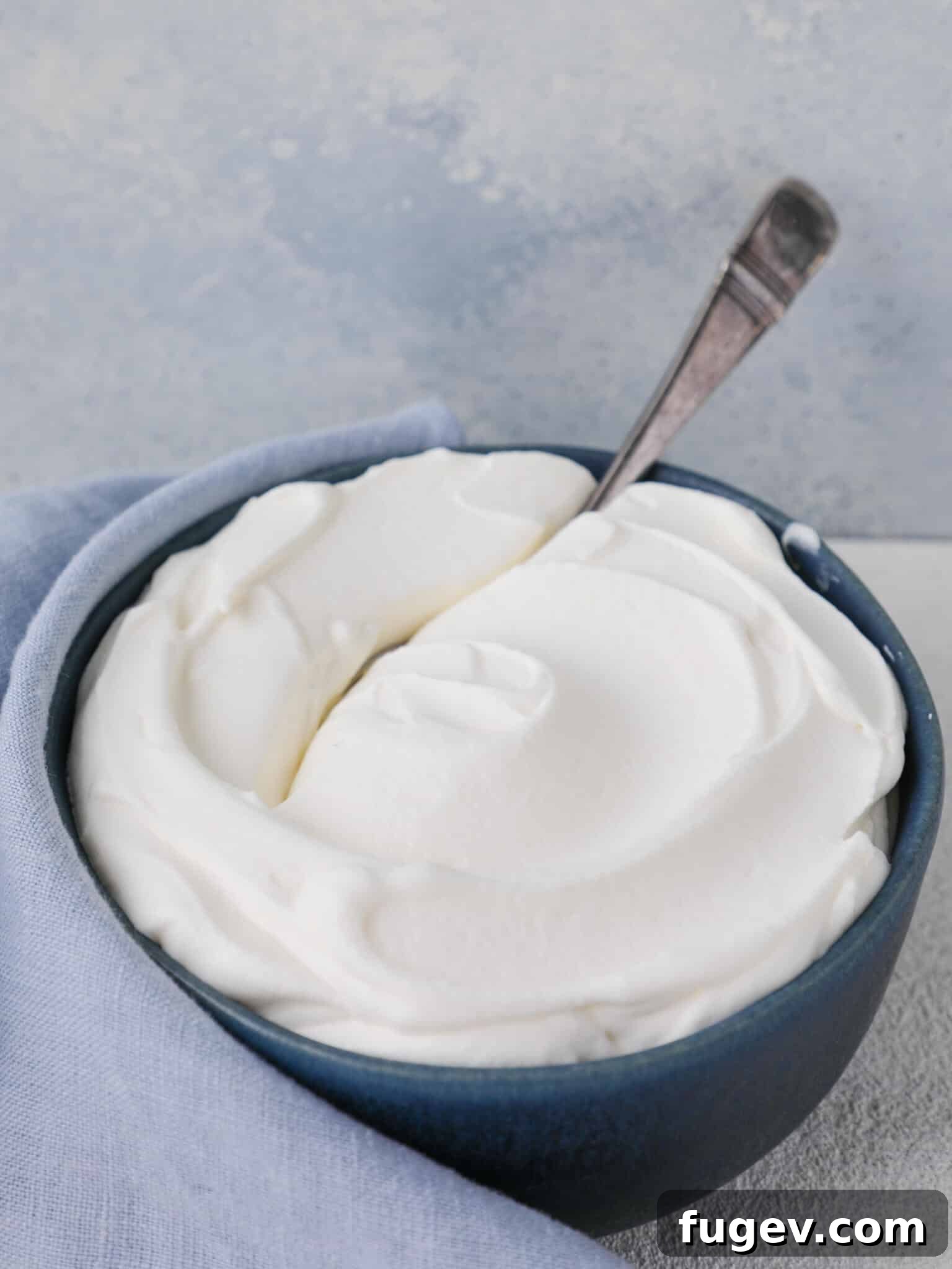 Fluffy Homemade Delight 5 Three bowls of homemade whipped cream, showing different stages of peak formation, against a blue background