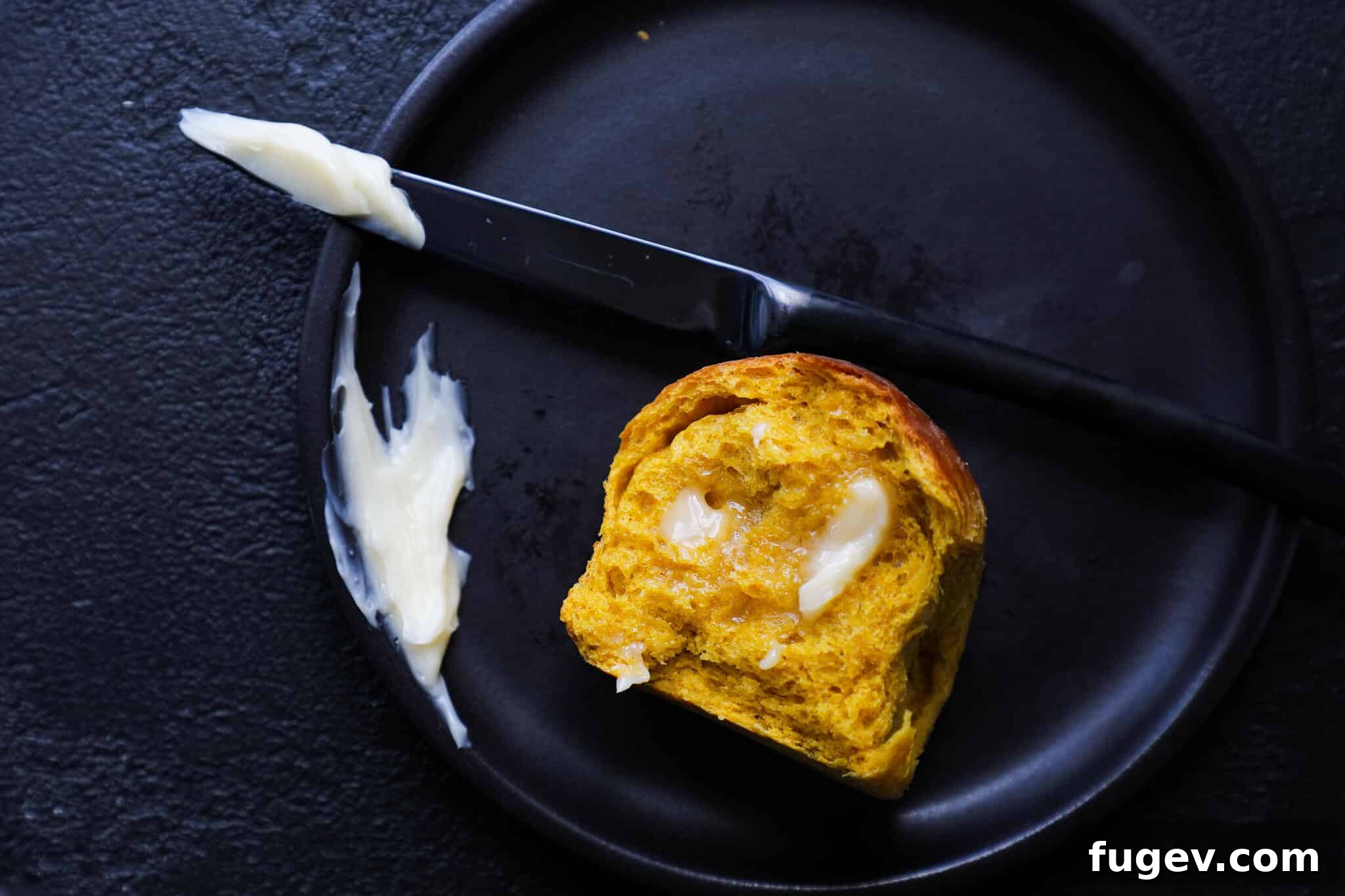 Velvety Maple Butter 3 Maple butter spread on a warm pumpkin spice roll, showcasing its creamy texture.