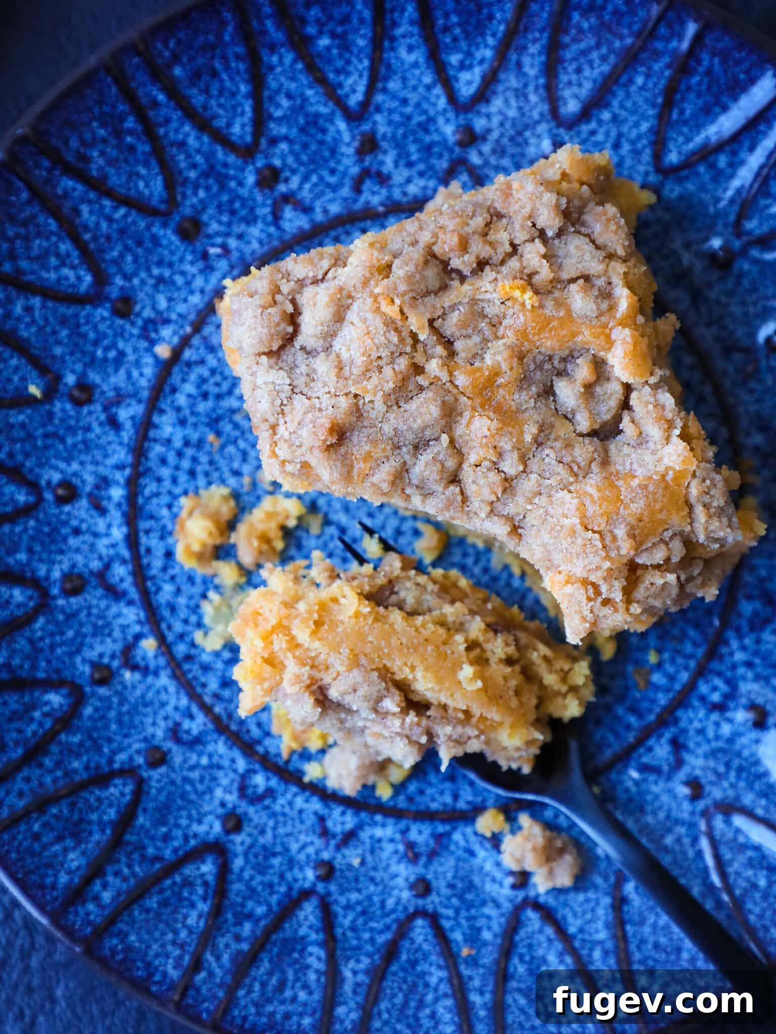 Spiced Pumpkin Streusel Cake 2 A perfectly sliced pumpkin coffee cake on a bright blue plate, showing its moist texture and rich streusel topping.