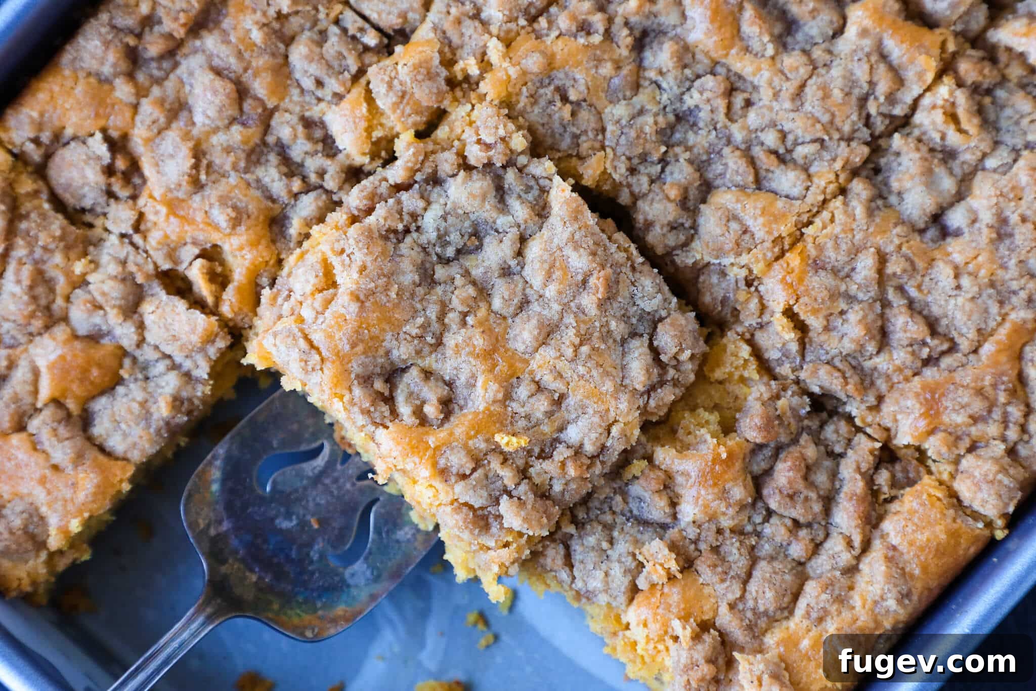 Spiced Pumpkin Streusel Cake 5 A large pumpkin coffee cake sliced and ready to be served from the baking dish, highlighting its generous crumb.