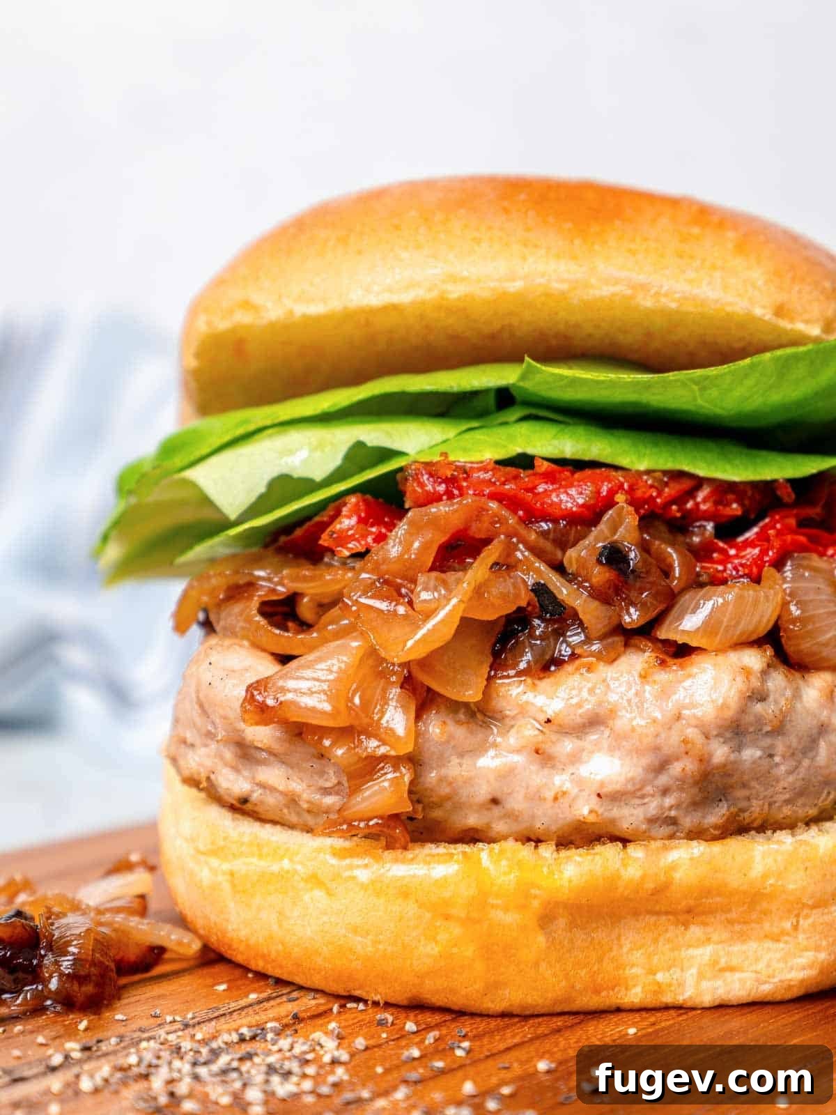 Juicy Homemade Turkey Burgers 2 Gourmet turkey burger assembled with golden caramelized onions, fresh lettuce, and a toasted bun, ready to be enjoyed.