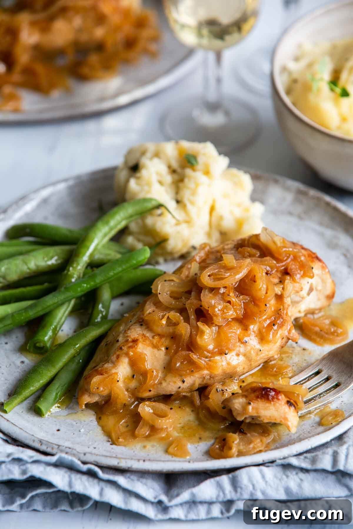 Golden Shallot Chicken 2 Chicken with shallots on a plate with a side of green beans, beautifully plated and ready to serve.