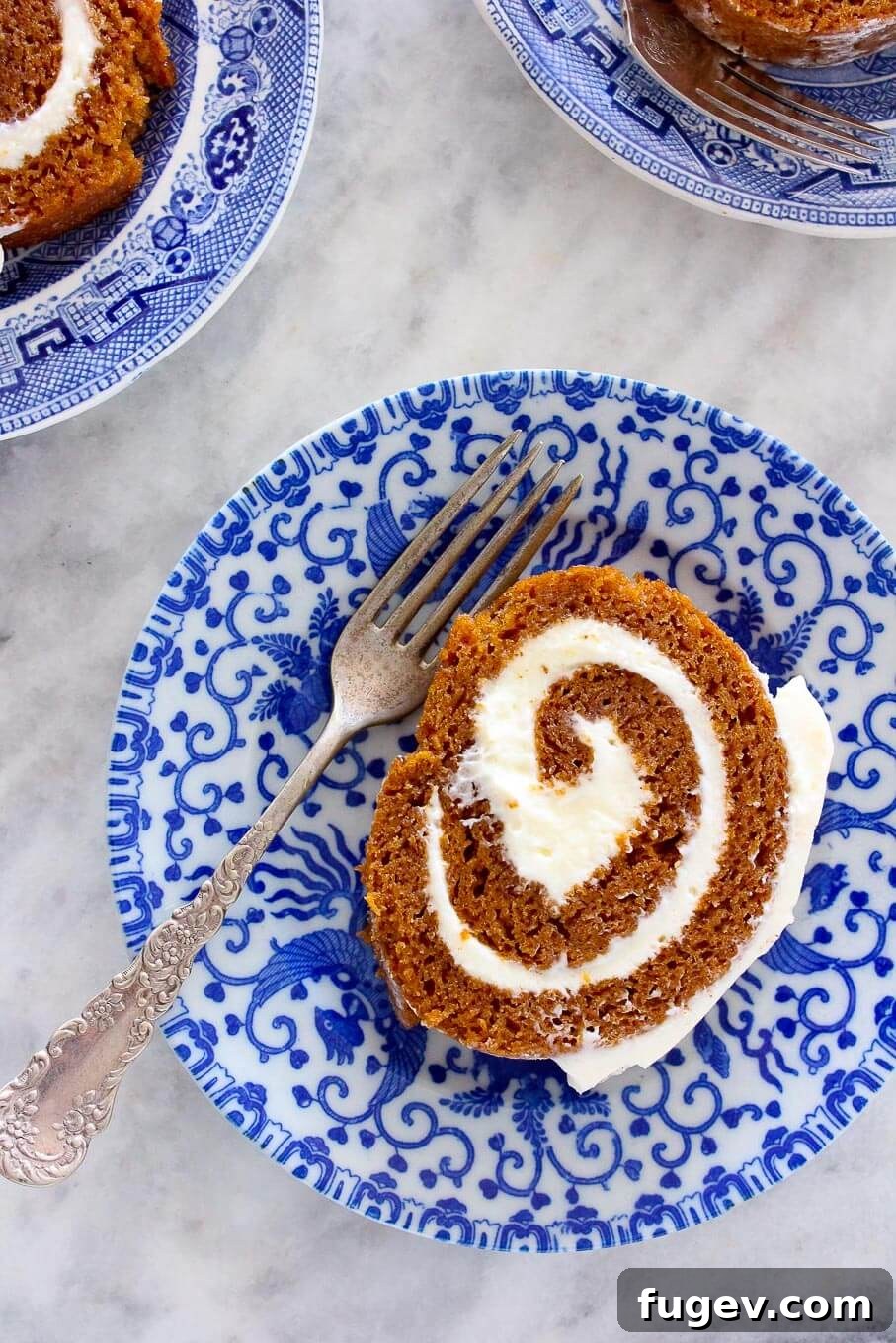 25 Irresistible Pumpkin Recipes for Fall 17 Pumpkin Roll slice with a vintage fork, showing layers of cake and cream
