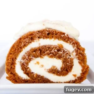 Sliced pumpkin roll revealing its creamy cream cheese filling