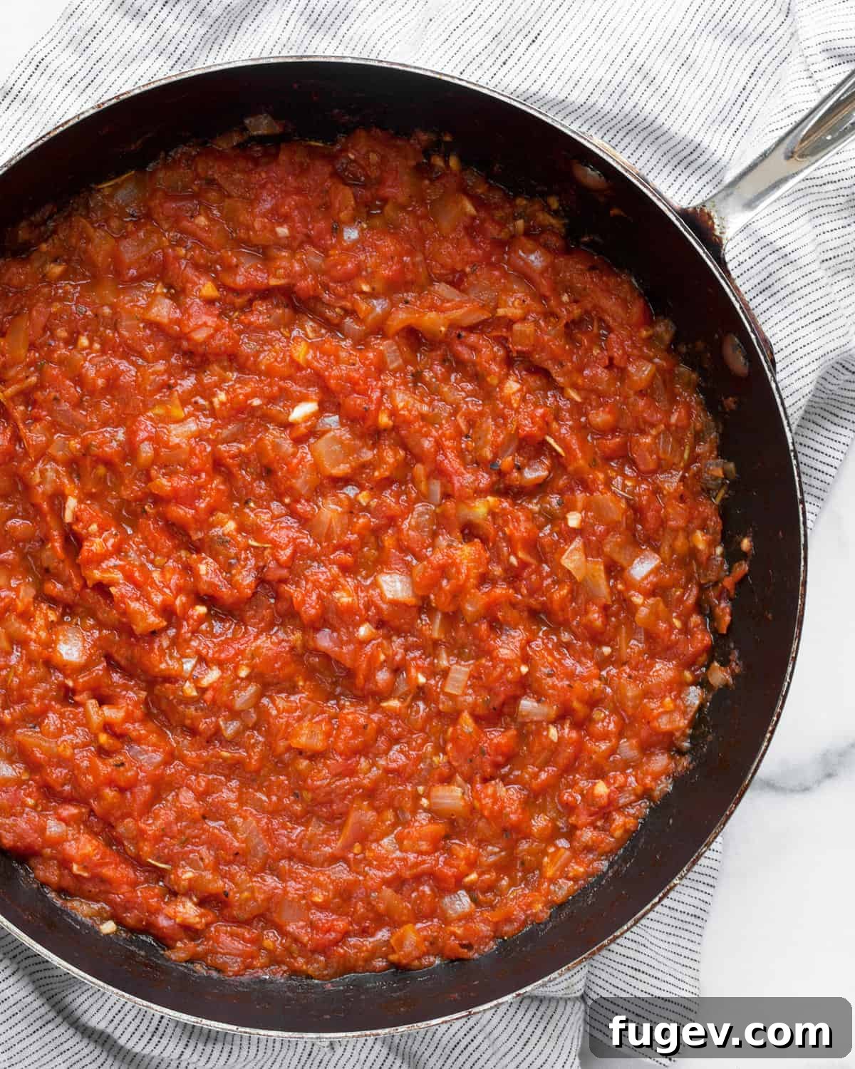 Garden-Fresh Roma Tomato Sauce 3 Rich Roma tomato sauce simmering in a skillet.